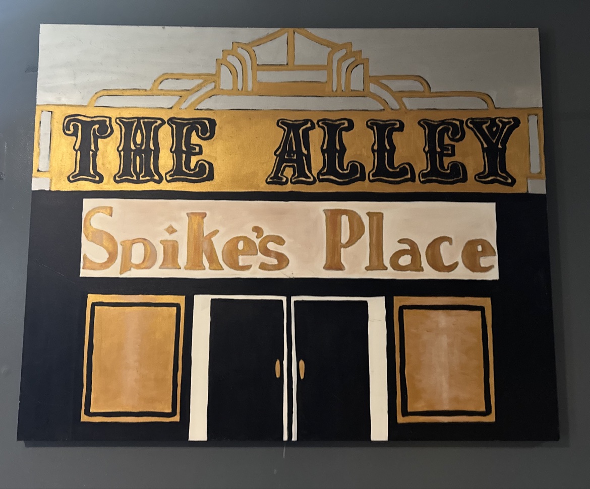 The hand-painted gold and black The Alley wall sign