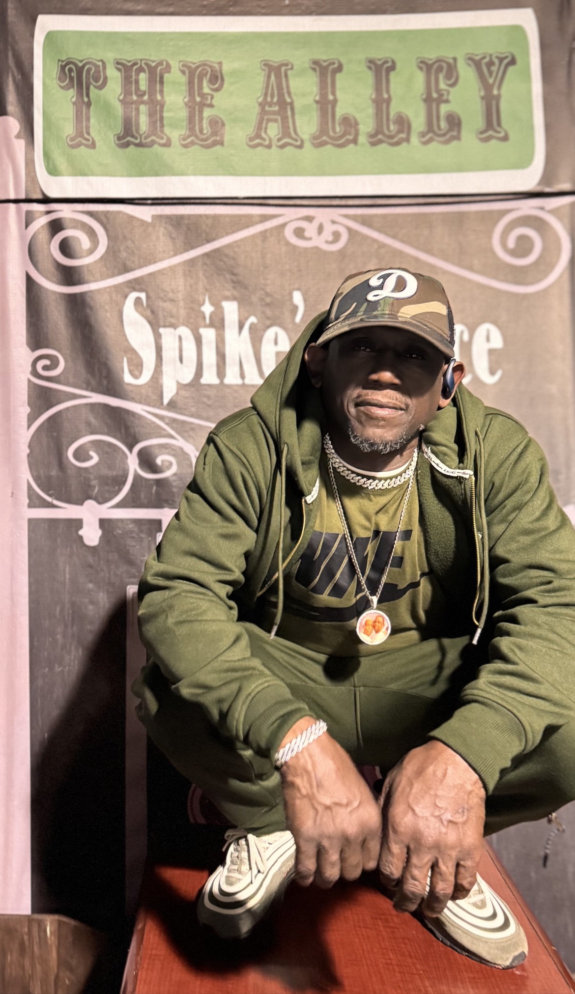 Spike crouched outside in front of the brown Spike's banner